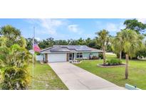 Charming single-story home with a well-manicured lawn, solar panels, and an American flag at 2541 Northway Dr, Venice, FL 34292