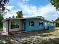 Charming single-story home with blue and white paint, inviting front porch, and well-maintained landscaping at 300 Dalton Blvd Blvd, Port Charlotte, FL 33952