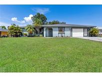 Charming single-story home featuring a well-maintained lawn and attached two-car garage at 7104 Castilla St, Port Charlotte, FL 33981