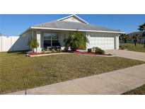 Charming single Gathering home with well-maintained lawn and landscaping, two car garage, and sunny front porch at 1405 Blossom Bayou Cir, Ruskin, FL 33570
