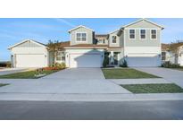 Two-story townhome with light blue exterior, two-car garage, and landscaping at 9144 Gulf Haven Dr, Parrish, FL 34219