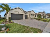 Two-story house with a three-car garage and a nicely landscaped front yard at 7474 Sea Manatee St, Parrish, FL 34219