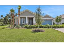 Single-story home with a two-car garage and landscaped yard at 7470 Sea Manatee St, Parrish, FL 34219