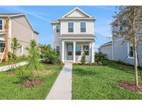 Charming two-story home featuring a well-manicured lawn and inviting front porch at 9031 Duany Ln, Lakewood Ranch, FL 34240