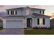 Two-story house with gray siding, dark gray door, and a three-car garage at 7454 Sea Manatee St, Parrish, FL 34219