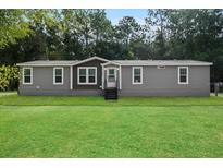 Gray manufactured home with green lawn at 10215 Poplar St, New Port Richey, FL 34654