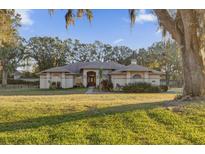 Charming two-story home with a landscaped front yard and mature trees at 26142 Mountainview Blvd, Brooksville, FL 34602