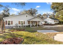 Beautiful single-story home with light gray stucco and stone accents, front porch, and well-manicured landscaping at 7157 Knoxville Dr, Webster, FL 33597