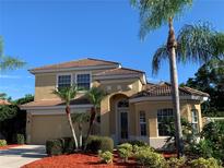 Inviting two-story home featuring lush landscaping, a tile roof, and a charming front entrance at 5271 Visionary Ct, Sarasota, FL 34233