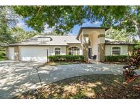 Beautiful home featuring lush landscaping, arched entry, and a spacious three-car garage at 17904 Singing Wood Pl, Lutz, FL 33548