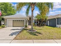 Charming single-story home featuring a well-manicured lawn and an attached two-car garage at 14820 Potterton Cir, Hudson, FL 34667