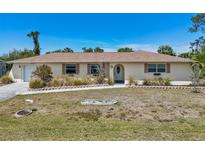 Charming single-story home featuring a well-manicured lawn and neutral exterior paint at 3067 Iverson St, Port Charlotte, FL 33952