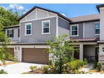 Charming two-story townhouse with a two-car garage and well-maintained landscaping at 17677 Nectar Flume Dr, Land O Lakes, FL 34637