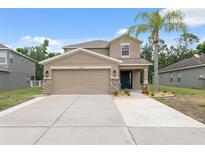Charming two-story home with a two-car garage, beautifully landscaped yard, and inviting front entrance at 12534 Chenwood Ave, Hudson, FL 34669