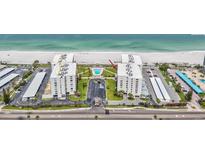 An aerial view of the beachfront condo buildings, swimming pool, parking lot, and meticulously kept grounds at 1400 Gulf Blvd # 701, Clearwater Beach, FL 33767