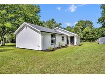 Charming home featuring new landscaping, a stucco exterior, and a lush green lawn at 13091 Old Crystal River Rd, Brooksville, FL 34601