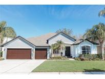 Charming single-story home featuring a three-car garage, beautiful landscaping, and a well-maintained lawn at 26620 Shoregrass Dr, Wesley Chapel, FL 33544