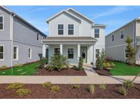 Charming two-story home with covered porch, landscaped front yard and light blue exterior at 130 Bragg Ln, Lakewood Ranch, FL 34240