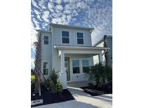 Charming two-story home featuring a covered porch, manicured landscaping, and a freshly paved walkway at 172 Eagleston Ln, Lakewood Ranch, FL 34240