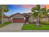 Charming single-story home featuring a two-car garage, tropical landscaping and a freshly manicured lawn at 4808 111Th E Ter, Parrish, FL 34219