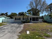 Charming single story home featuring a screened in porch, mature trees, and a spacious front yard at 9015 Bay Ne St, St Petersburg, FL 33702