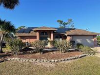 Charming single-story home with solar panels, attached garage, manicured front yard and mature plants at 3604 Bula Ln, North Port, FL 34287