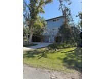 Blue two story home featuring mature landscaping and a concrete driveway, exuding curb appeal at 1612 Pocatello St, Sarasota, FL 34231