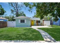 Charming home with a well-manicured lawn and inviting yellow door for a warm, sunny entrance at 418 40Th S Ave, St Petersburg, FL 33705