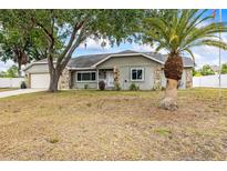 Charming single-story home with stone accents and a well-manicured lawn and mature landscaping at 2204 Krista Ln, Brandon, FL 33511