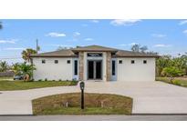 Stunning single-story home featuring a modern exterior, fresh landscaping, and a spacious driveway at 5479 S Biscayne Dr, North Port, FL 34287