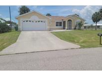 Charming single-story home featuring a two-car garage, well-kept lawn, and inviting curb appeal at 4611 Herman Cir, Port Charlotte, FL 33948