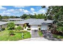 Charming single-story home with lush landscaping, well-manicured lawn, and a two-car garage at 6948 W Country Club N Dr, Sarasota, FL 34243