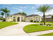 Charming single-story home with a beautiful lawn, circular driveway, and well-maintained landscaping at 14041 Bassingthorpe Dr, Spring Hill, FL 34609