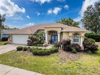 Well-maintained single-story home with landscaped front yard, paved driveway and a charming blue double-door entrance at 1052 Archway Dr, Spring Hill, FL 34608
