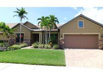 Charming single-story home showcasing lush landscaping, a well-manicured lawn, and a two-car garage at 13639 Salinas St, Venice, FL 34293