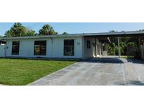 Charming single-story home featuring a covered parking area and well-maintained front lawn at 21970 Cellini Ave, Port Charlotte, FL 33952