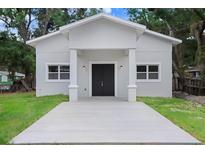 Newly renovated single story home featuring a gray exterior and walkway leading up to a covered porch with a black front door at 14 S Forest St, Plant City, FL 33563