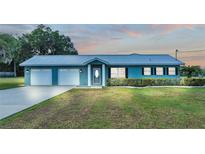 Ranch-style home with double garage and manicured lawn at 6110 Downing St, Dover, FL 33527