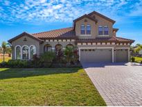 Two story house with tile roof, landscaping and a large driveway at 10469 Meadowrun Dr, Lithia, FL 33547