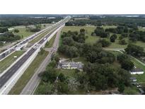 Expansive aerial view of a property with mature trees, a yellow home, and convenient highway access at 750 Charlie Taylor Rd, Plant City, FL 33566