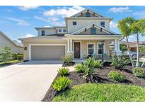 Charming two-story home with a well-manicured lawn and inviting front porch at 7048 White Willow Ct, Sarasota, FL 34243