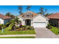 Charming single-story home featuring a stone facade, brick driveway, and well-maintained landscaping at 2932 Sky Blue Cv, Bradenton, FL 34211