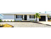 Charming single-story home with a well-maintained gravel yard and a freshly painted white exterior at 1046 Lee St, Englewood, FL 34224