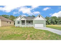 Charming single-story home featuring a well-manicured lawn and an attached two-car garage at 12484 Green Oak Ln, Dade City, FL 33525
