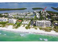 Stunning aerial view of beachfront condos with lush landscaping and beautiful water views at 605 Sutton Pl # 102, Longboat Key, FL 34228