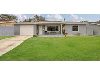 Inviting single-story home featuring a well-kept lawn and a cozy front porch at 3432 Monticello St, Holiday, FL 34690