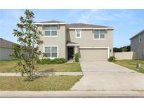 Charming two-story home featuring a two-car garage and well-maintained front yard at 8009 Sail Clover Ln, Zephyrhills, FL 33540