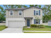 Charming two-story home features blue shutters and a well-maintained lawn and a two car garage at 203 Lovely Ct, Plant City, FL 33566