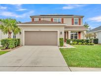 Charming two-story home with red shutters, manicured lawn, and a spacious two-car garage at 9015 Spruce Creek Cir, Riverview, FL 33578