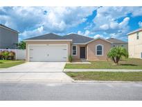 Charming single-story home features a two-car garage, landscaped yard, and neutral exterior paint at 3425 San Moise Pl, Plant City, FL 33567